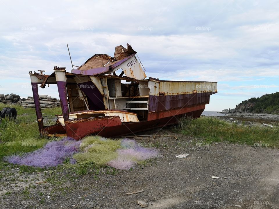 A ship wreck with a multicolored fish net. La Tourelle, Québec, Canada