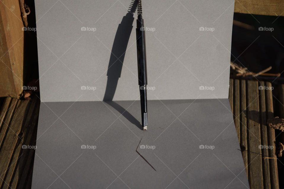 Eyebrow pencil close-up on a gray background.
