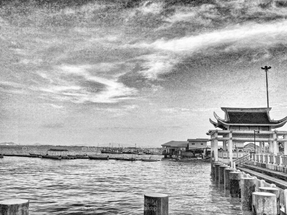 Public harbor in gray-ish color with boats aligning and ready for the day's work.