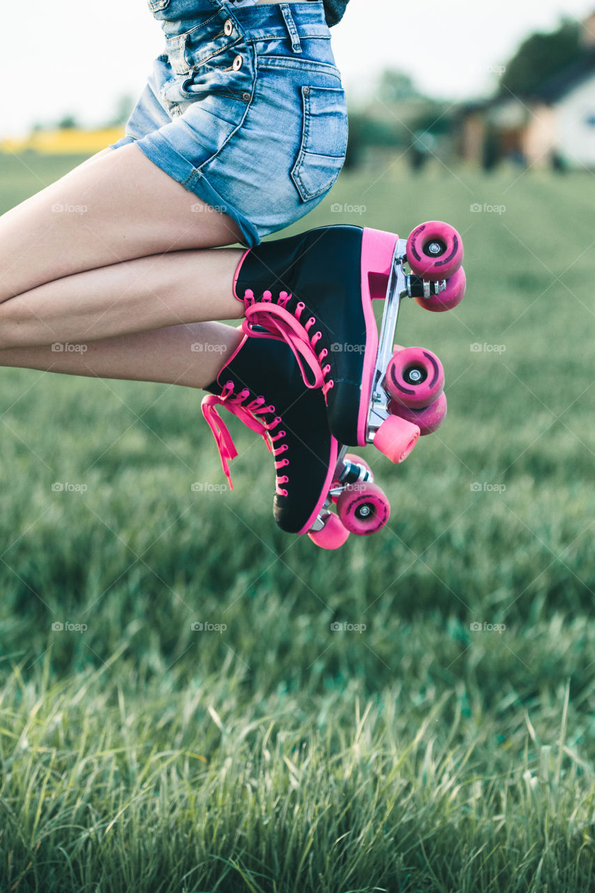 Teenage smiling happy girls having fun rollerskating, jumping, spending time together on summer day. Teenage smiling happy girls having fun walking outdoors, hanging, spending time together on summer day. Real people, authentic situations