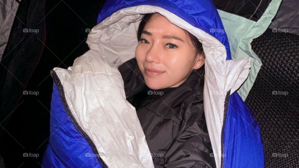 Portrait of a young woman smiling in a sleeping bag