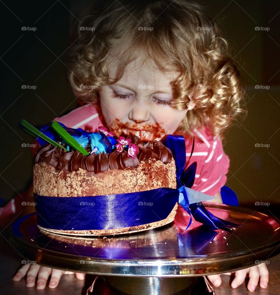 Naughty girl takes bite out of her mom’s birthday cake