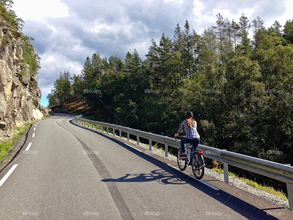 Girl riding bicycle on a country side road 