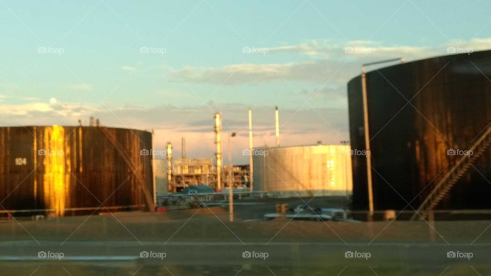 Glow of sunset on refinery oil tanks