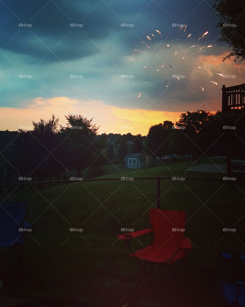 Fireworks going off as a storm approaches at dusk