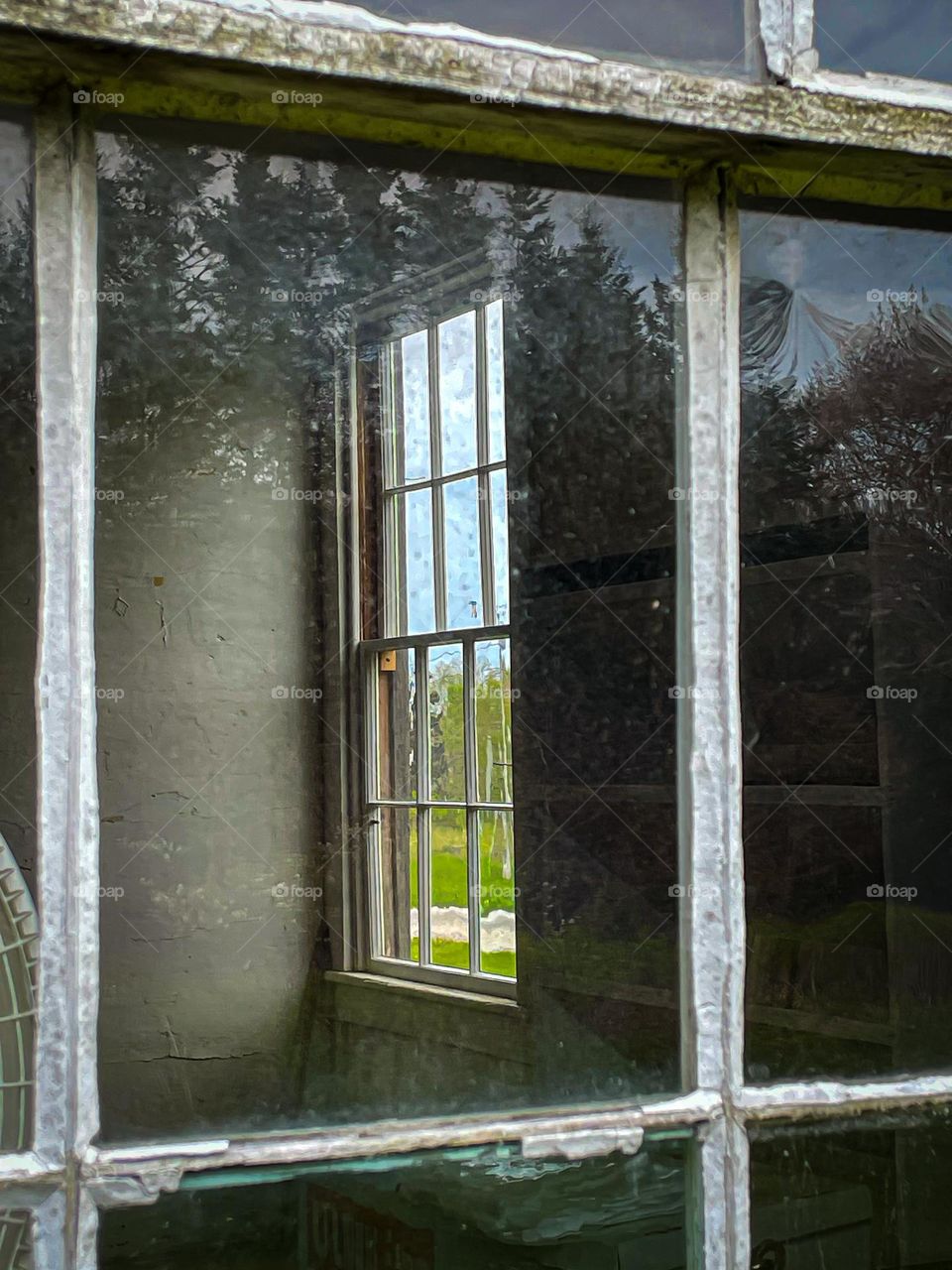 “Outside, looking in… And back out again.” View through the outside winds of an old house.