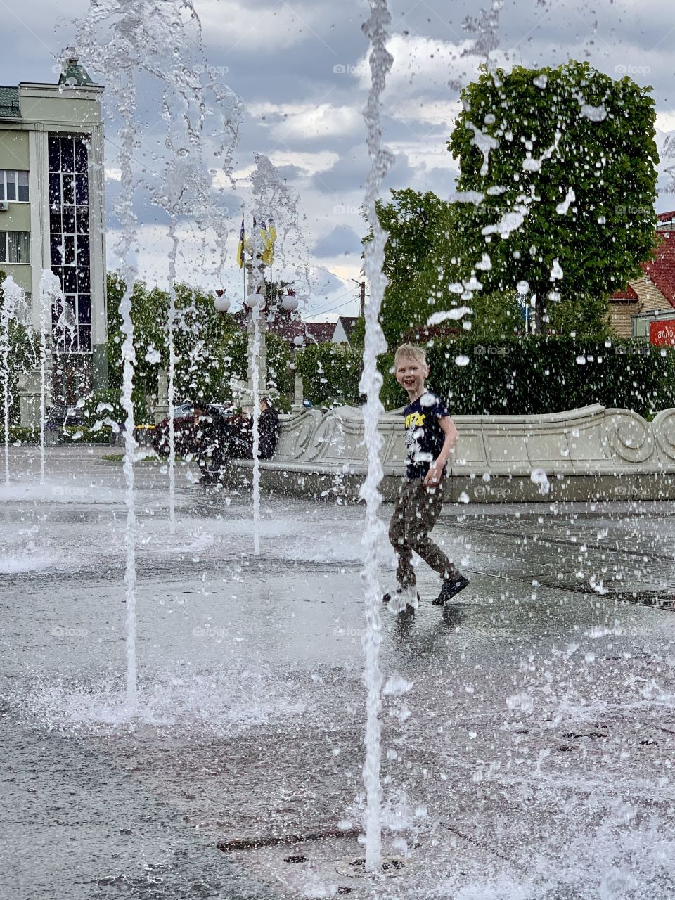 Smiling boy and city fountains 