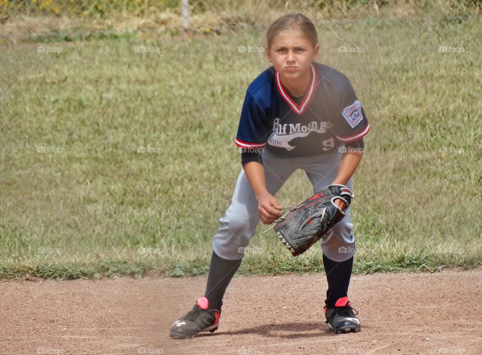 Girl Playing Baseball. Young Girl Playing American Little League Baseball
