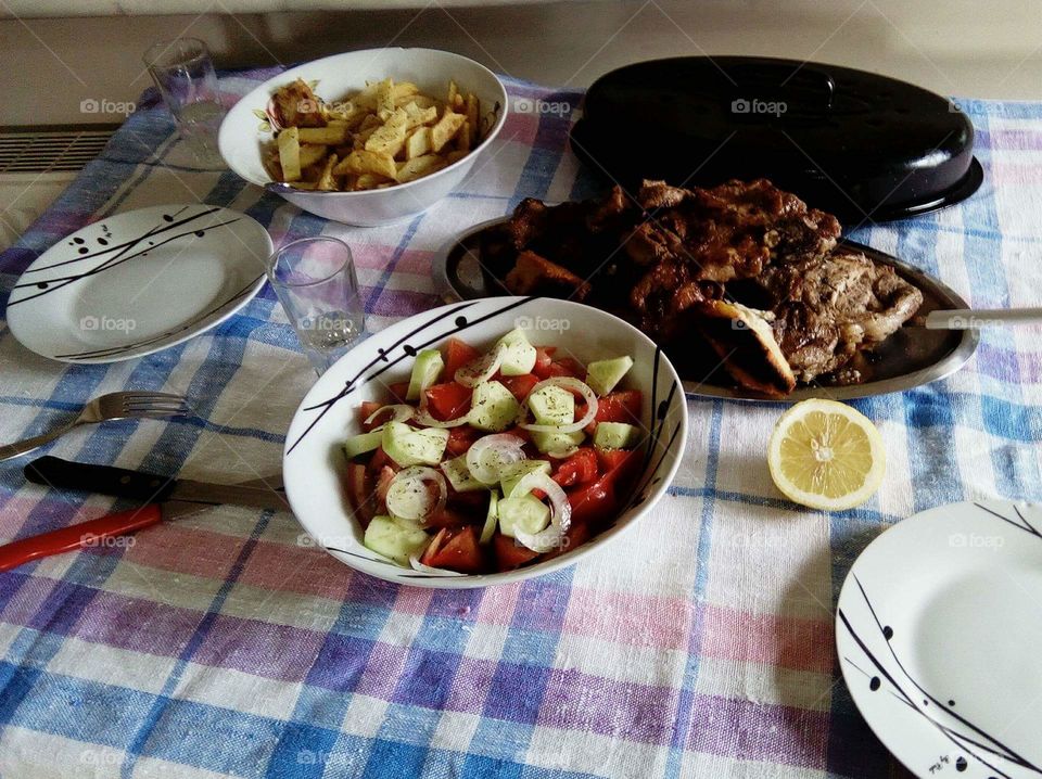 Grilled meat with fries and mediterranean salad
