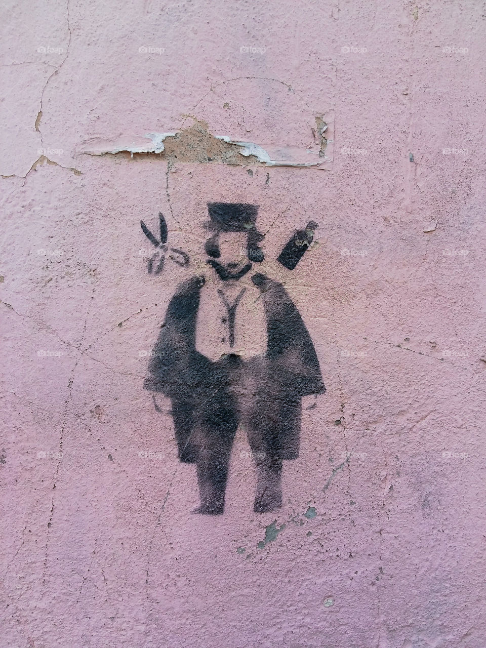 graffiti on the wall a man in a hat near the barber's scissors and spray