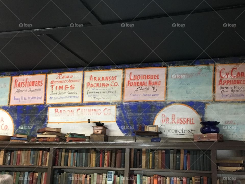 More books along with posters and other artifacts above the top shelf tells the story.