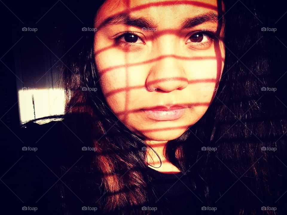 Girl's face with shadow in the form of grid