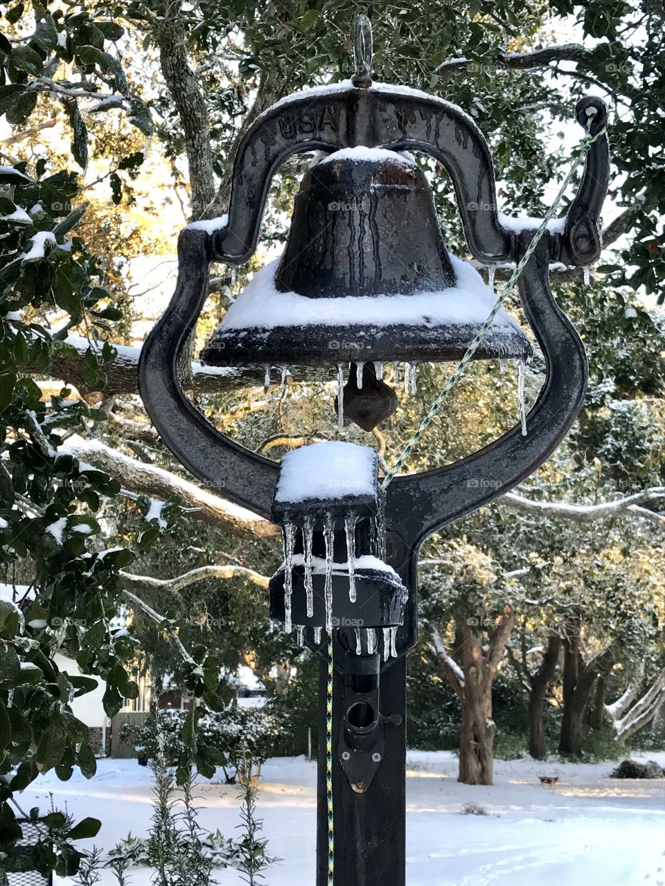 Snow, icicles and ice on the farm bell