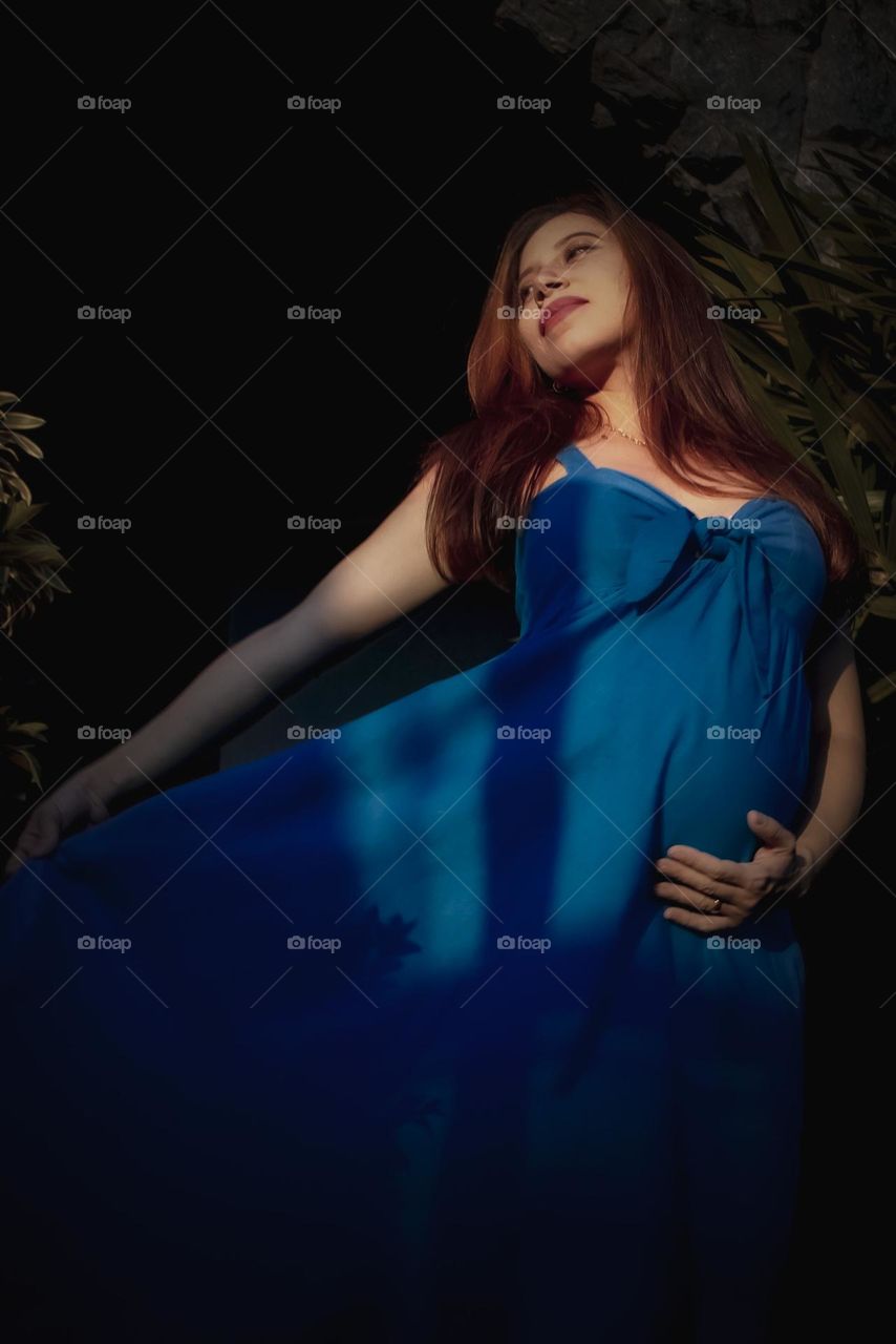 Photograph of pregnant woman in blue dress.