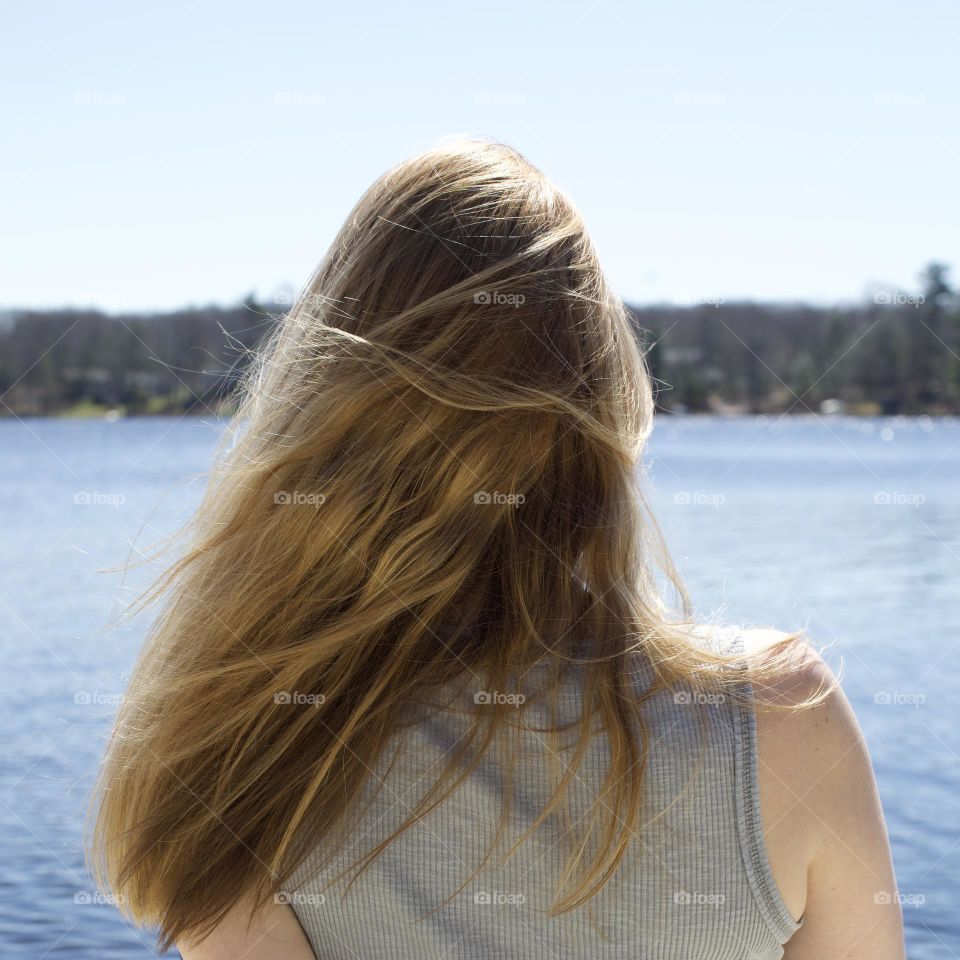 The best Summer days are by the Lake; Woman facing a lake during a blue sky, sunny say