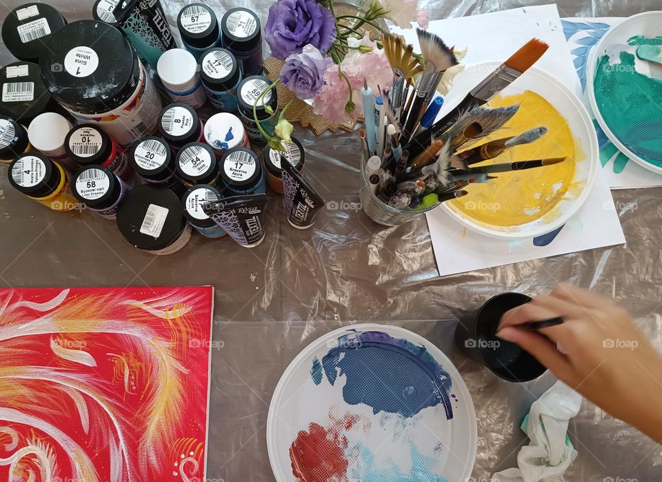 Artist's desk with paints, brushes and paintings
