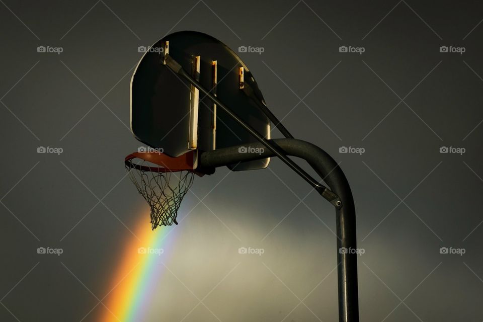 Basketball hoop against rainbow