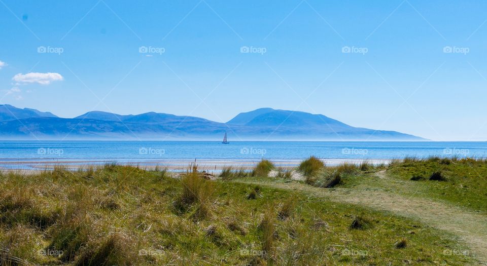 Distant view of sailboat sailing in sea