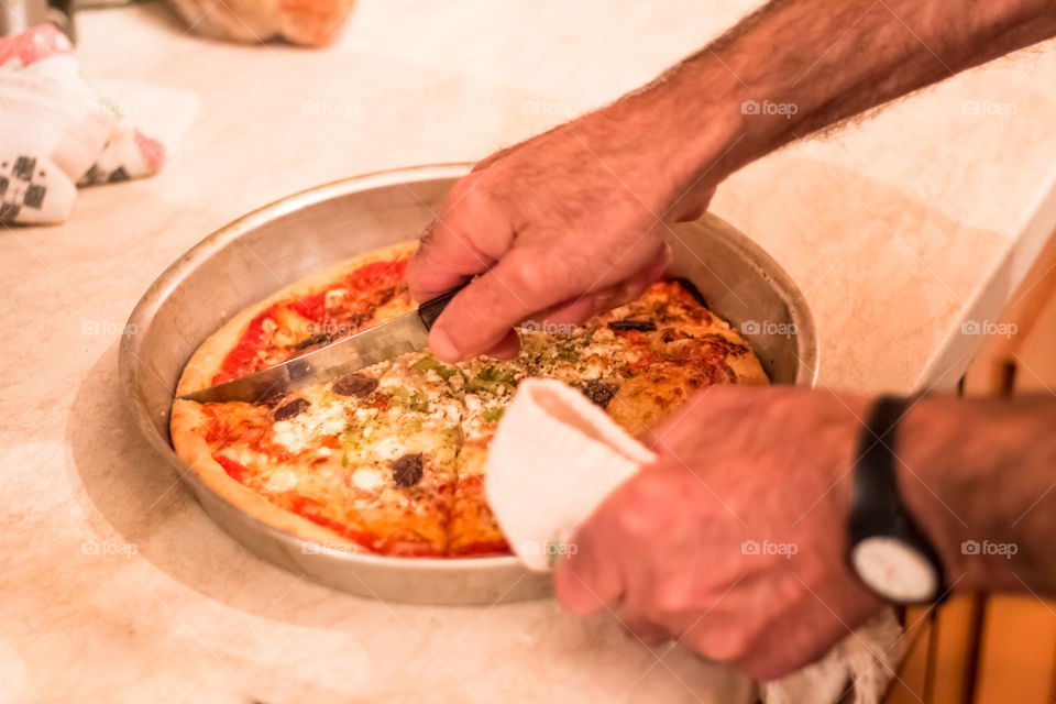 Man Cutting Pizza At Home
