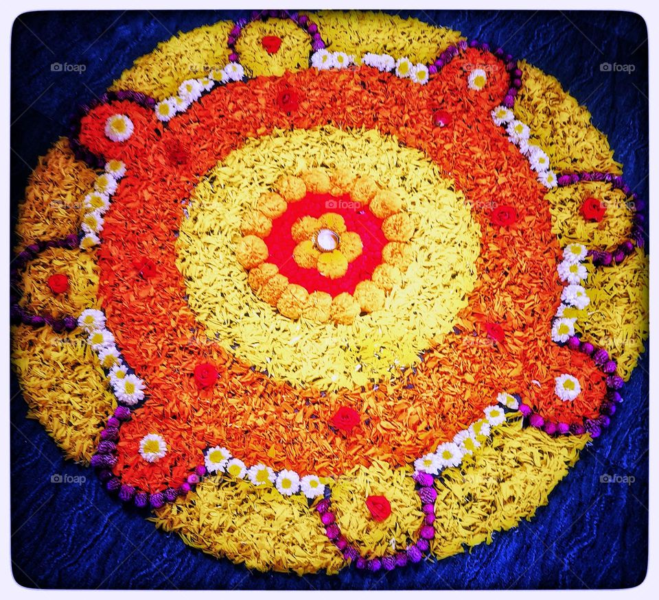 Rangoli is made with different flowers and  signs of wealth and happiness. It is generally created outside of the main entrance door 🚪of the home.