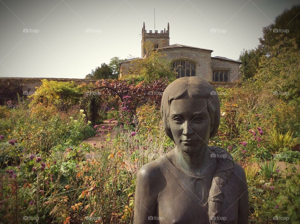 Statue in walled garden with church in the background 