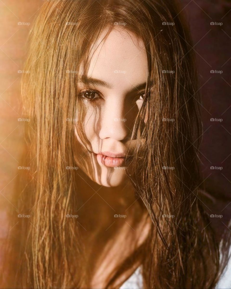 Artistic close-up of a woman with wet brown hair. His face is not visible because it is censored, giving rise to a sense of mystery and interest