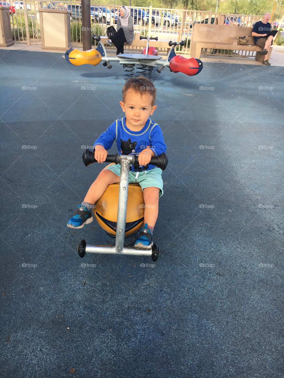 Cute toddler in blue shirt playing at the park