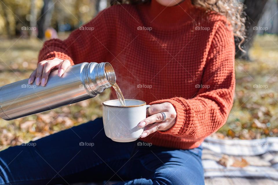 woman pouring tea on picnic