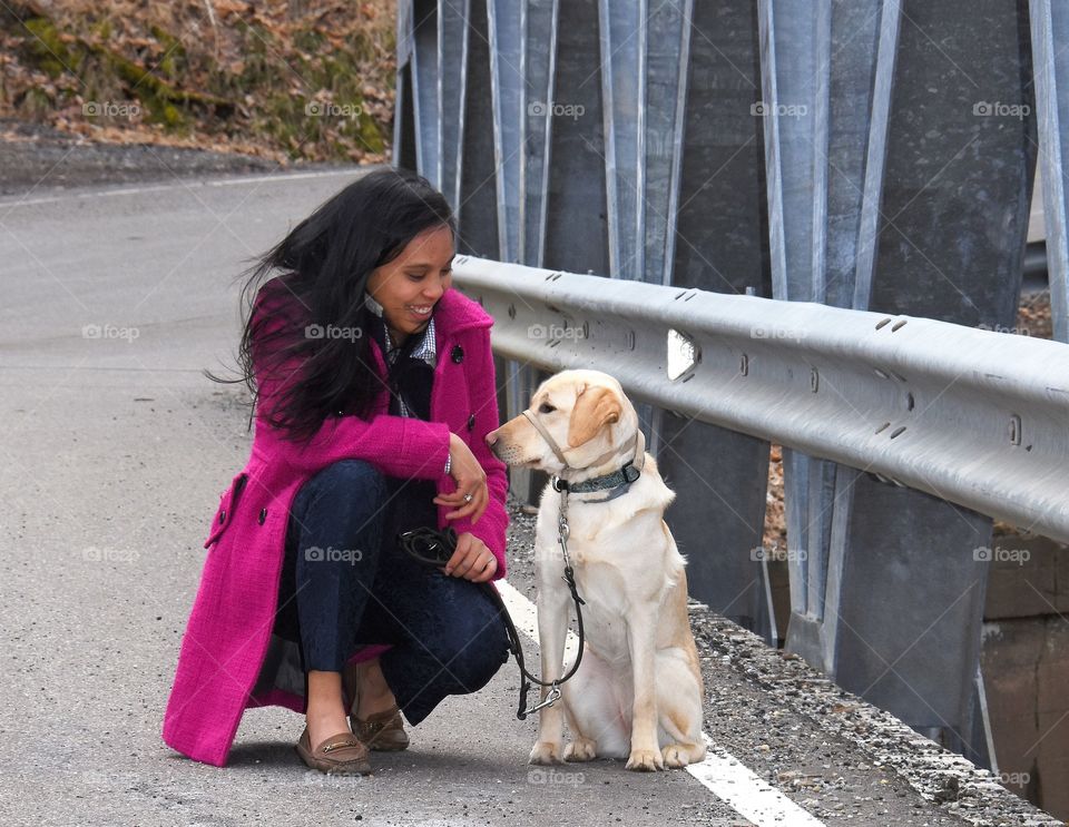 Girl with her dog by a bridge