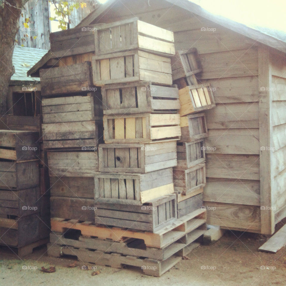 Stacks of apple crates against a structure.