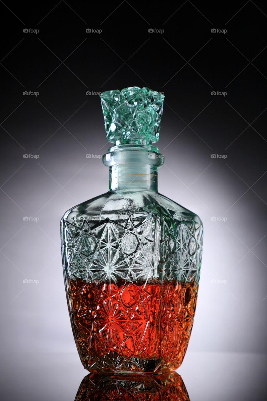 Glass decanter with whisky drink inside.