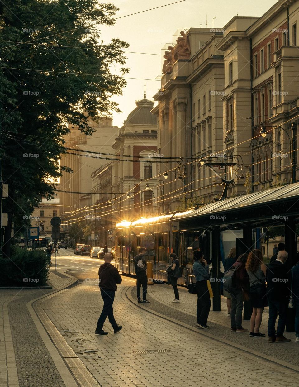 tram arriving at the stop during a beautiful sunset