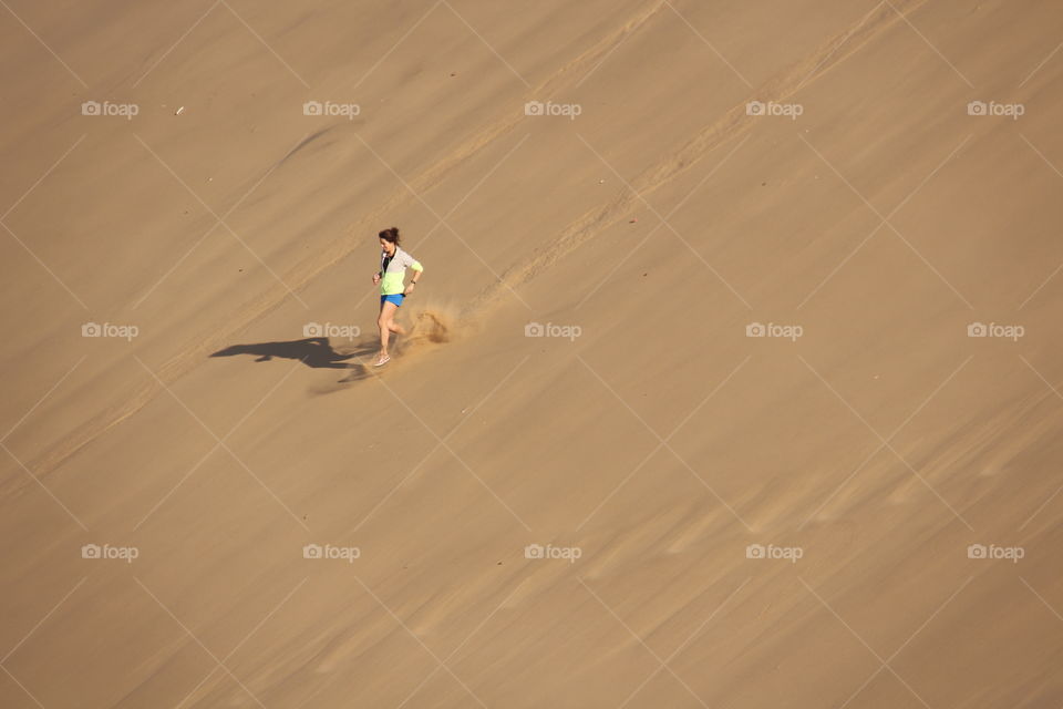 girl running down dune. trip to dune 7 Namibia