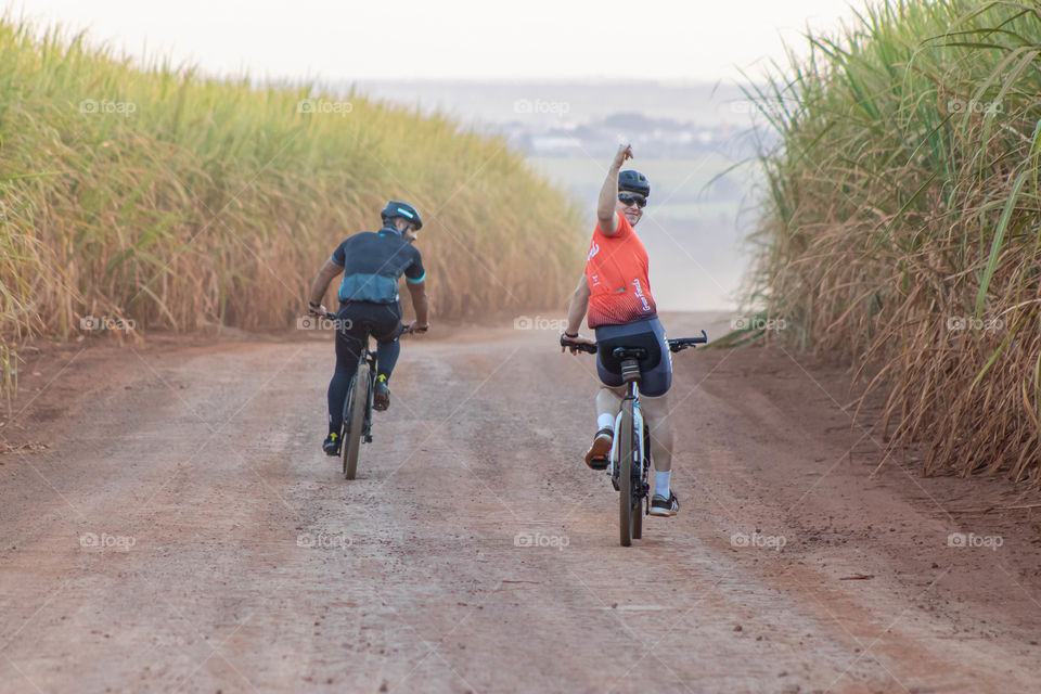 Amigos descendo a ladeira de bicicleta feliz.