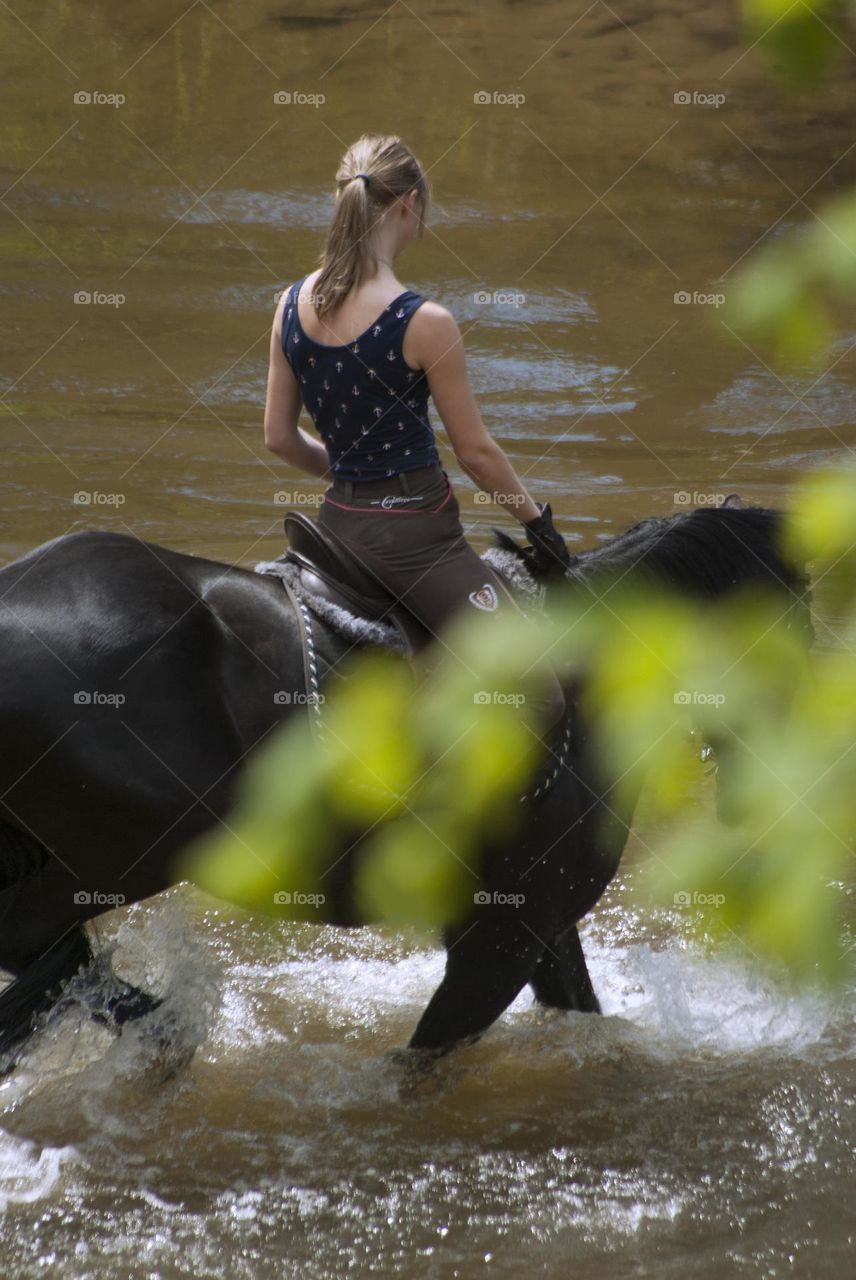 Girl jumps on the horses on the field