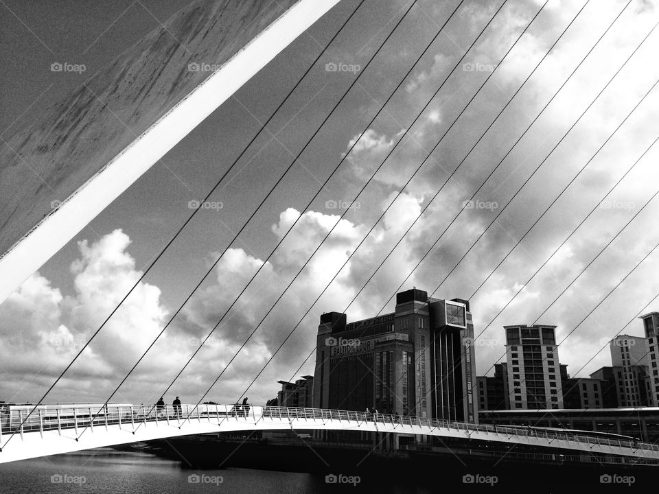 B&W photo of The Millennium Bridge over The River Tyne with The Sage Gallery in the background 