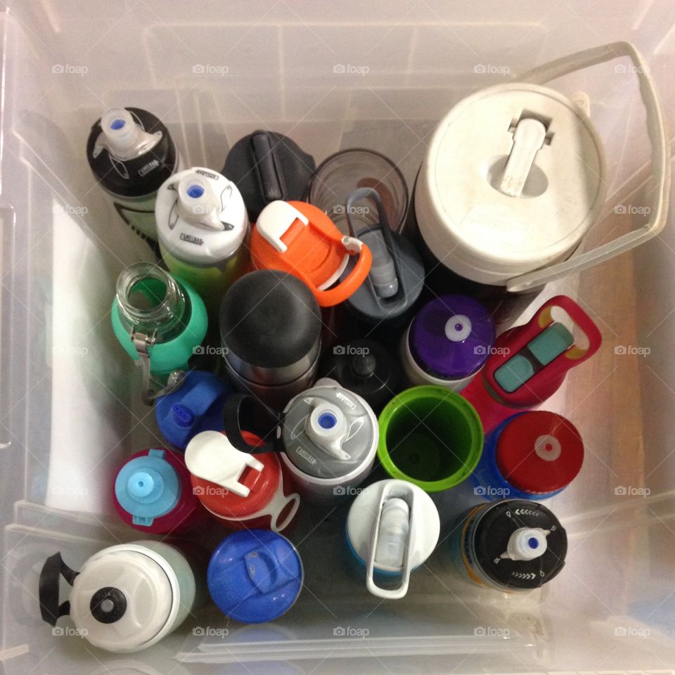 Various water bottles in a clear plastic bin