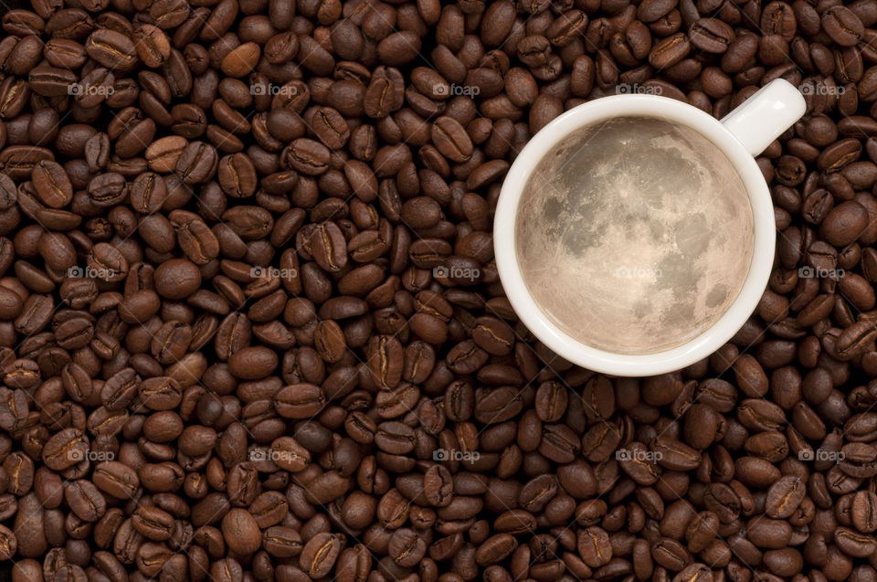 Cup with coffee on coffee beans background