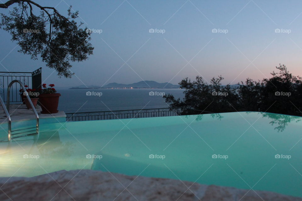 Infinity swimming pool sunset 