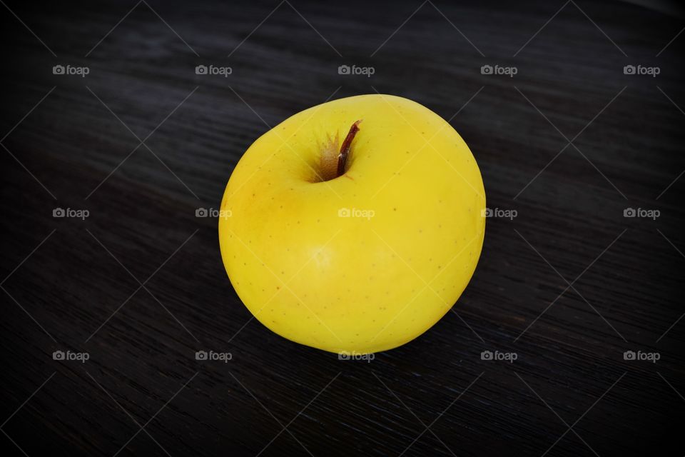 Close-up of yellow apple on table