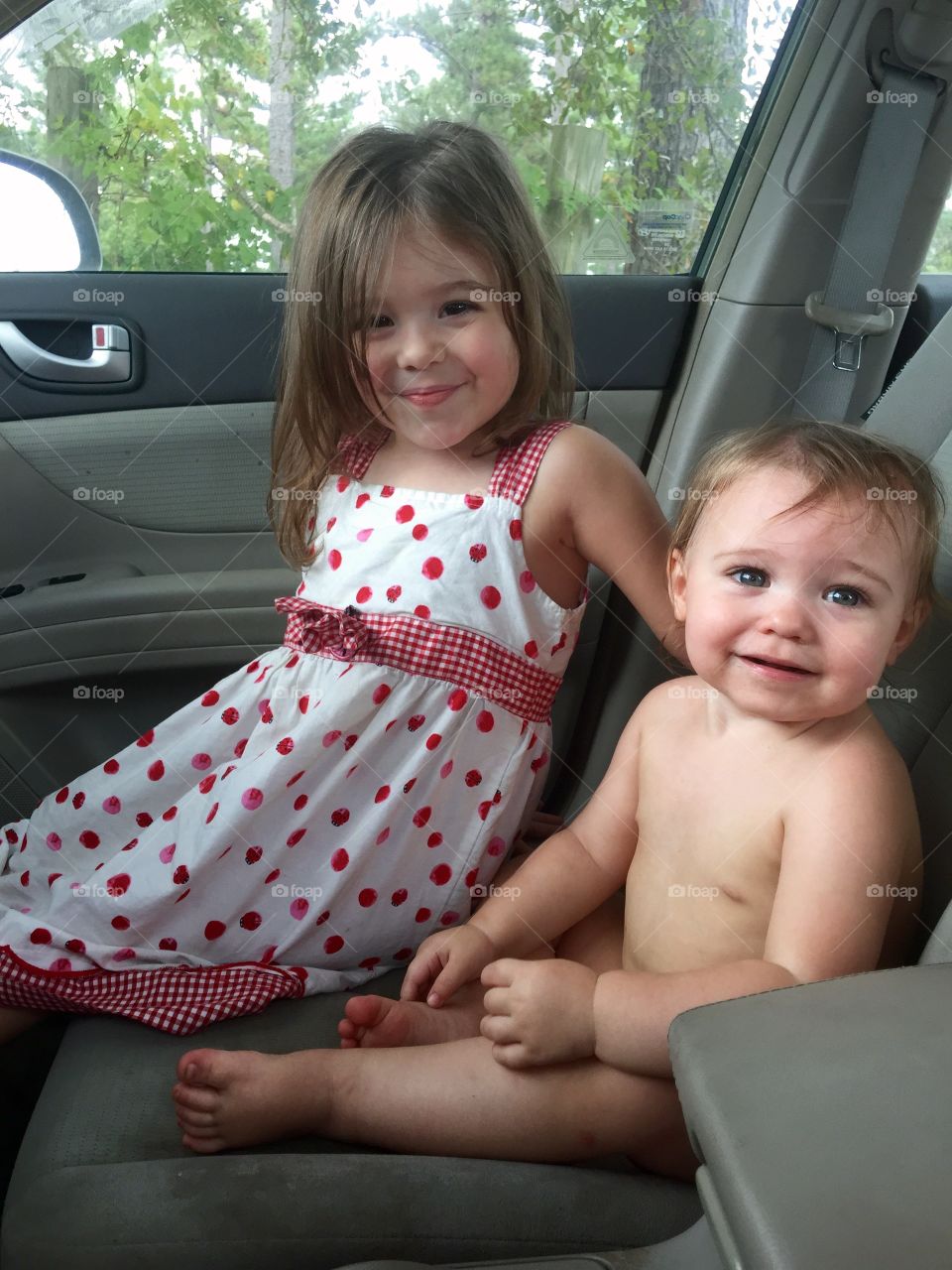 Sister and brother sitting in car
