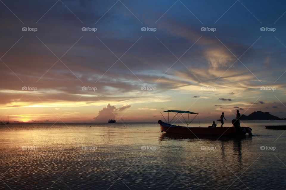 Golden hour in Koh Tao, Thailand. A beautiful colourful sunset, you can feel the peace and the local customs. Small boats.