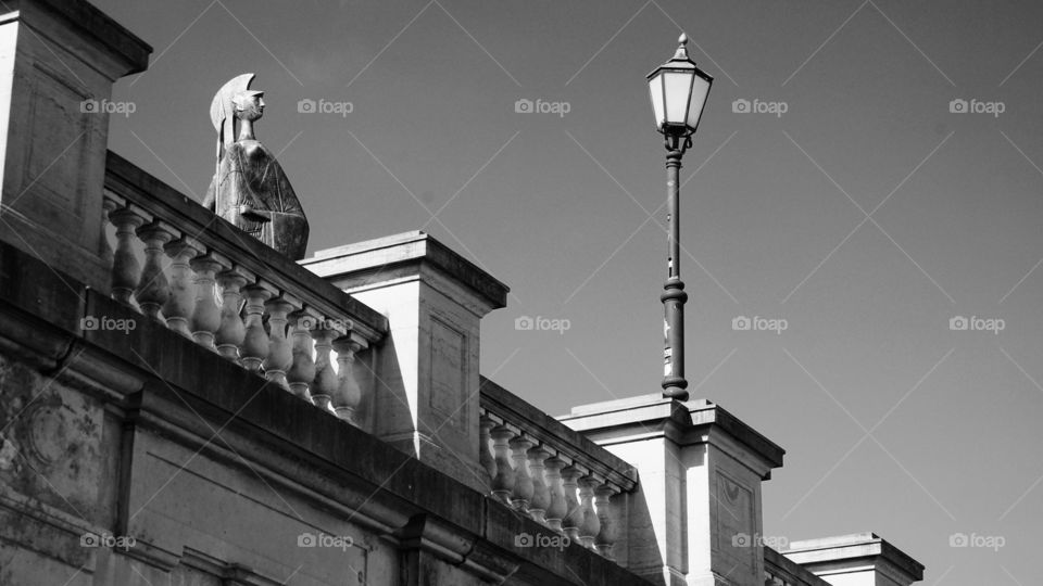 Sculpture and lamp post on an old stone bridge in Antwerp.