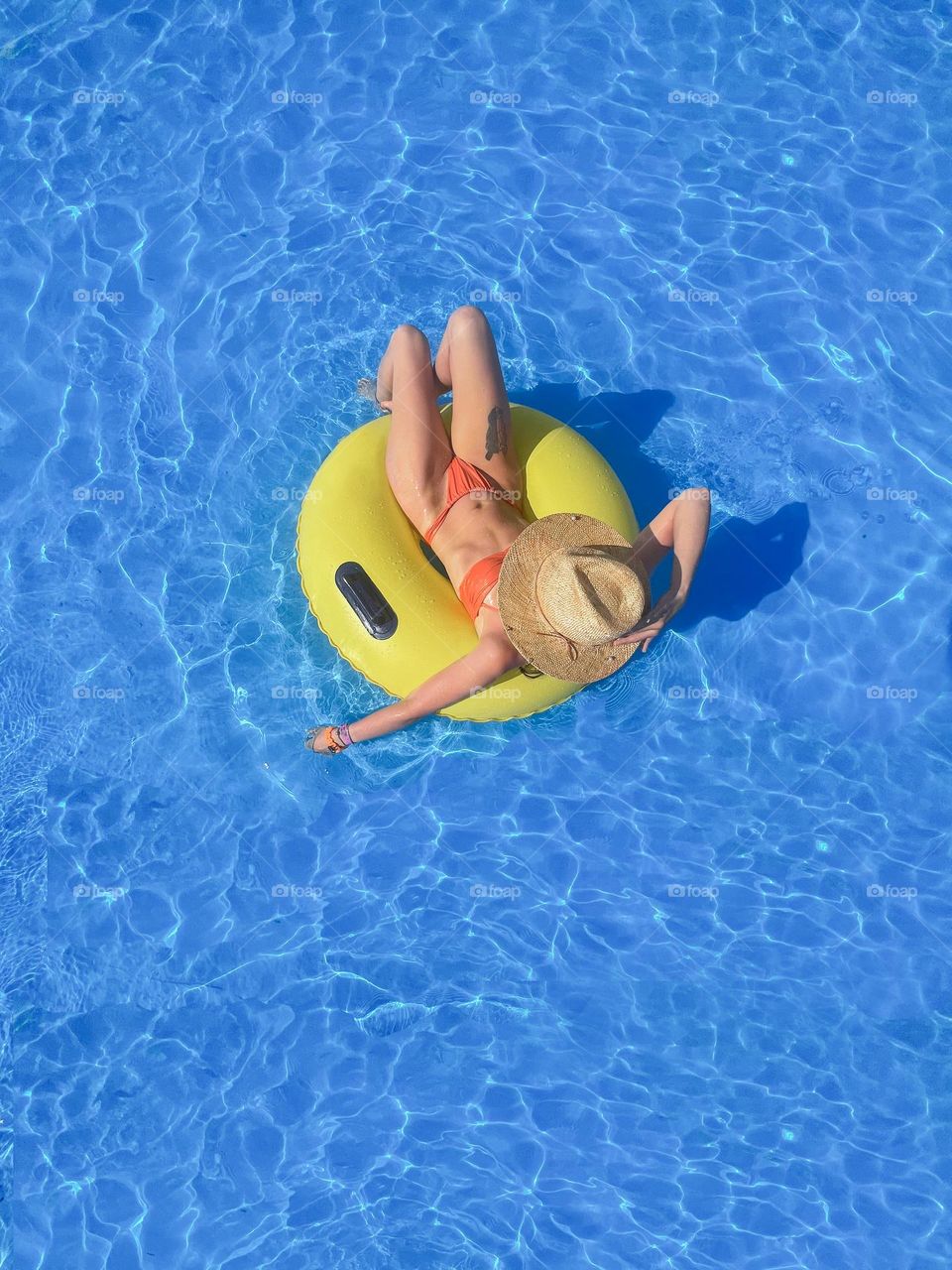 A woman swims in a pool on an inflatable circle