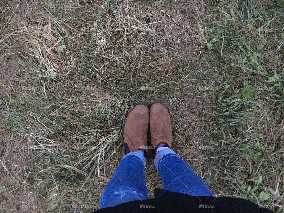 Boots on grass, blue jeans 