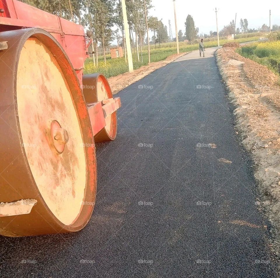 A roller standing on a road under construction in the village.