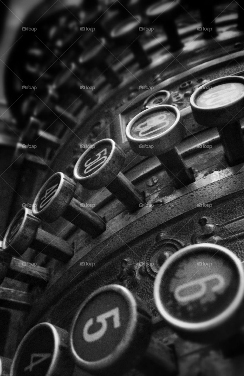 Old stye cash register keys. A black and white closeup view of an old cash clunky mechanical cash register. 