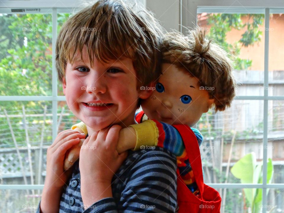 Boy With Doll. Young Boy Carrying His Toy Doll
