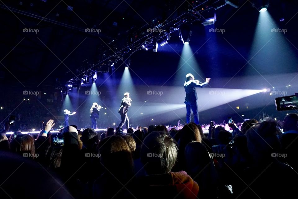 Beams of light at a concert and low strobe lighting moving through the audience 