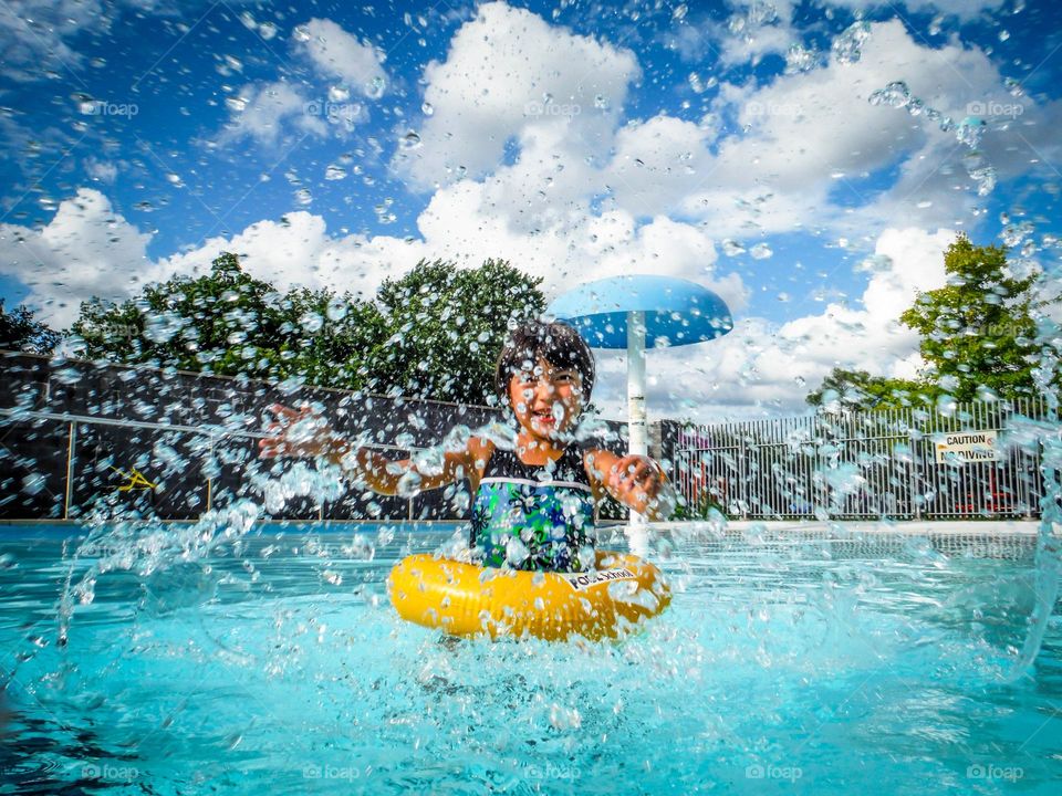 Cute girl is having fun in an outdoor swimming pool